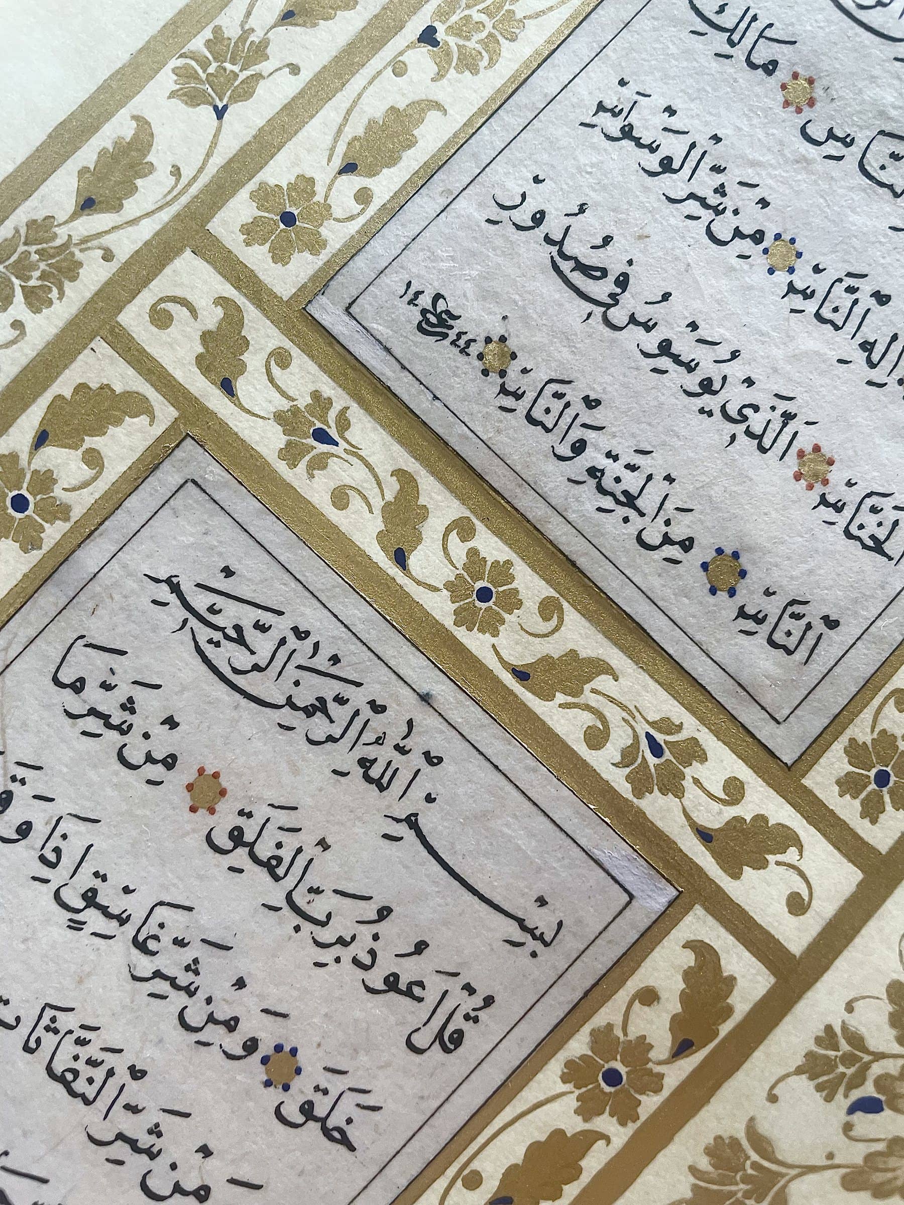 Hat yazılı sayfa bölmeleri ve aralarındaki altın çiçek motifli tezhip detayı